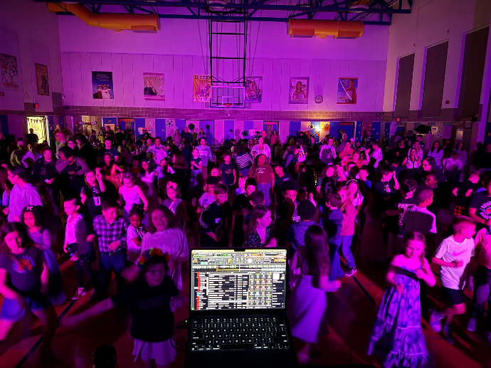 children at a school dance with pink lighting